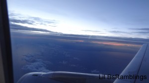 A strip of red between clouds with a clear blue sky above the clouds