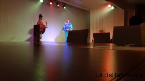 Two ladies dressed in traditional Japanese outfits dancing with flower branches.