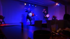 Three eisa dancers jumping and dancing around the stage