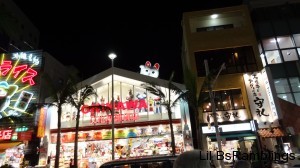 A shop with a lot of life size superhero statues in the windows