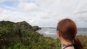 A side view of me overlooking the waves crashing against moss covered rock