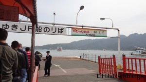 A Japanese attendant counting the passengers as the ferry approaches the pier.