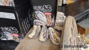 Oyster shells next to a box of oysters in their shells