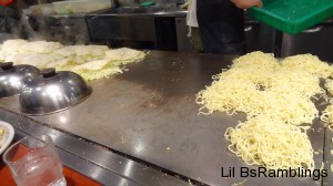 The noodles cook on one side of the huge grill while the vegetables and pork cook on the other side.