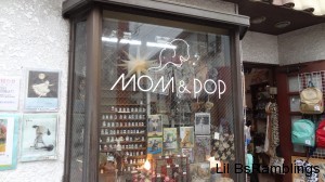 A shop window with vintage looking items behind glass that says MOM&POP