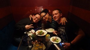 Red headed me, black- haired Jen, and barely-haired Jon posing over food.