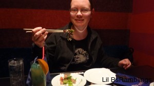 I'm holding a piece of lettuce in my chopsticks before I eat it.