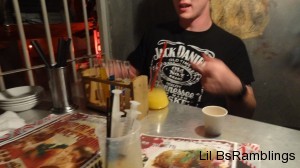 John behind a large beaker of orange juice and a set of small beakers to mix into it.