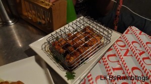 Some fried and seasoned chicken in a cage.