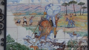 A tile mosaic of a knight on horseback lancing some sheep while labourers egg him on.